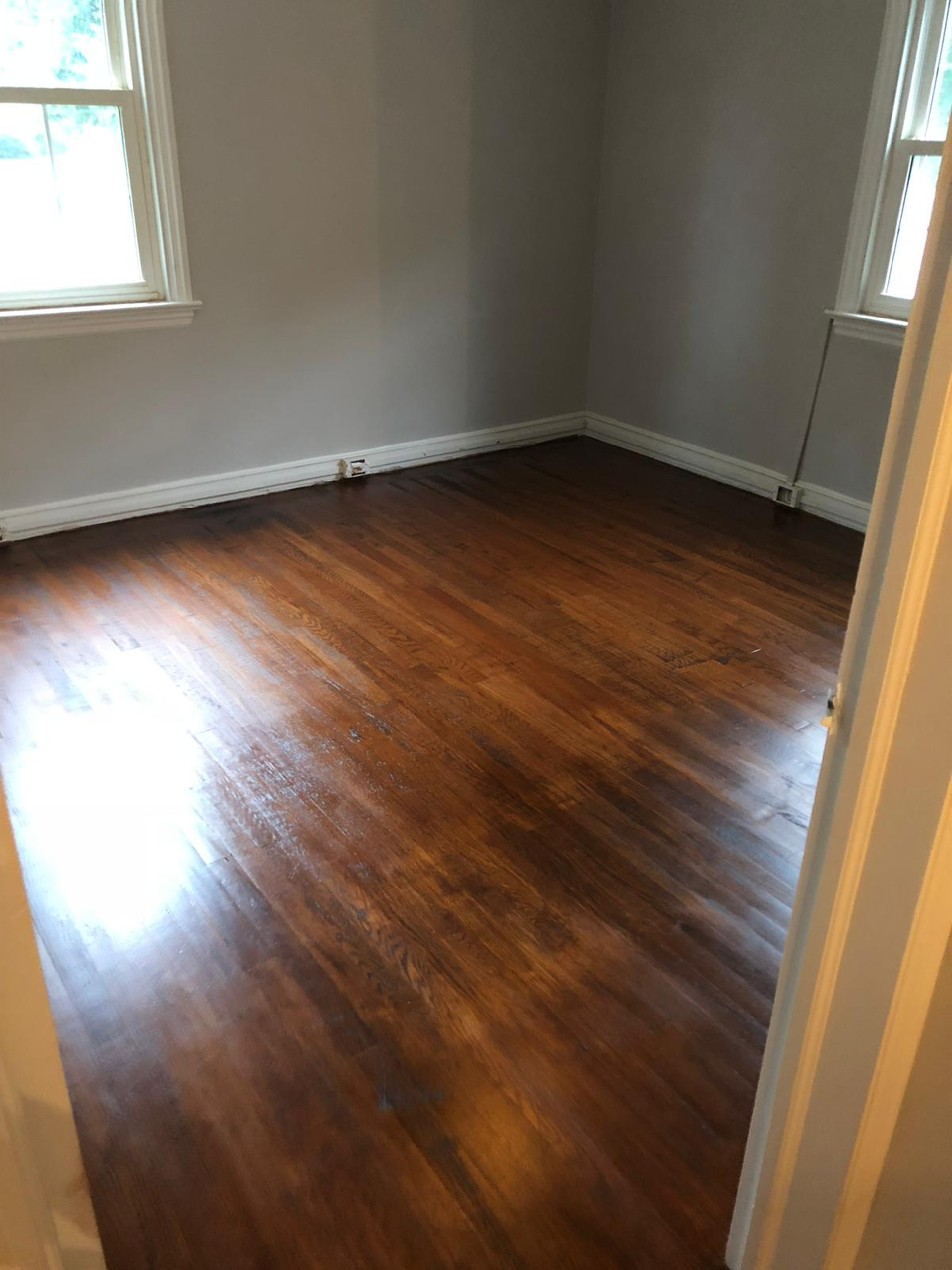 Bedroom with a refinished dark hardwood floor and gray walls