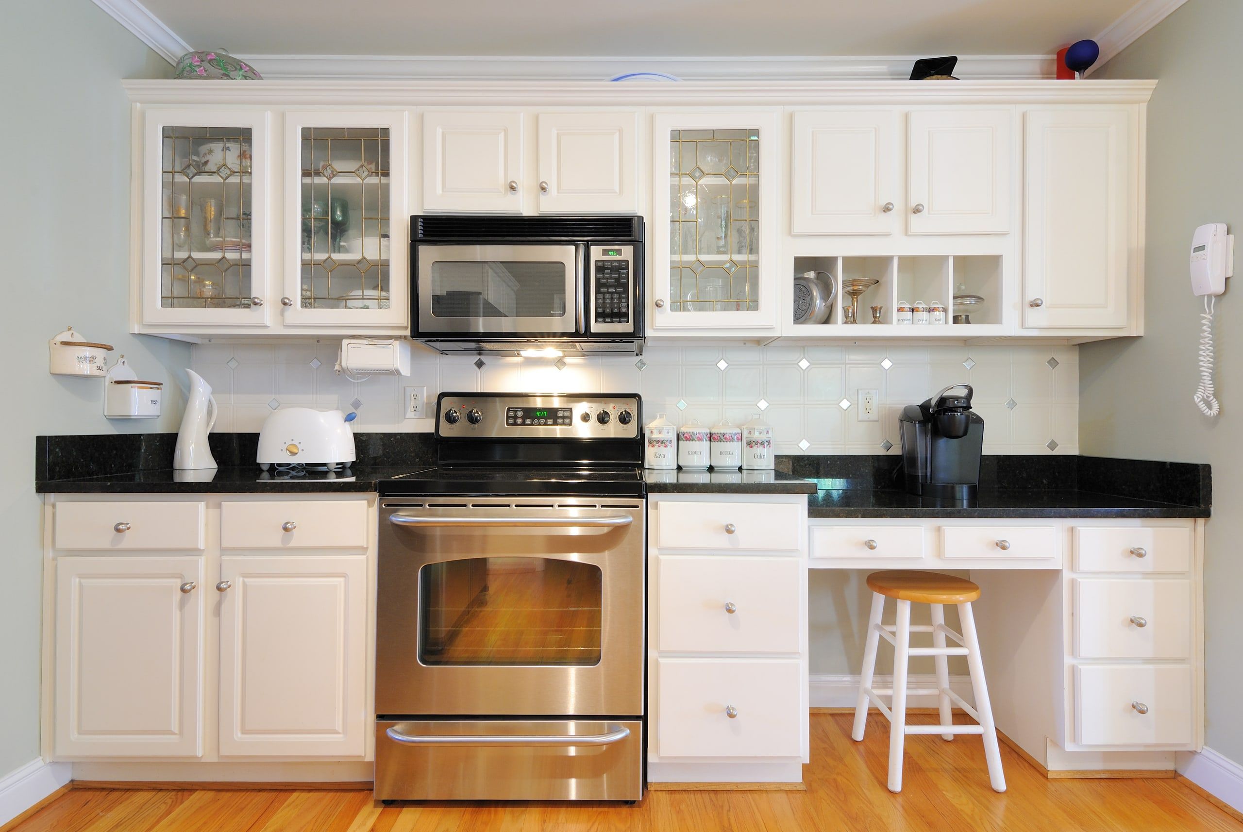 Kitchen with white painted cabinets and dark countertops